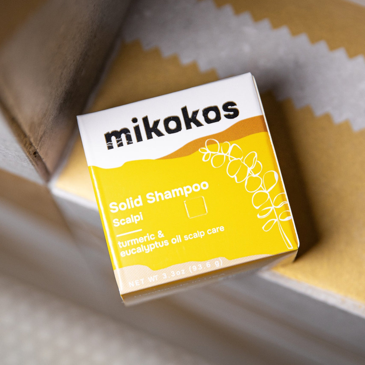 Caja de Scalpi Shampoo en Barra de Mikokos en primer plano, con cúrcuma y eucalipto para el cuero cabelludo